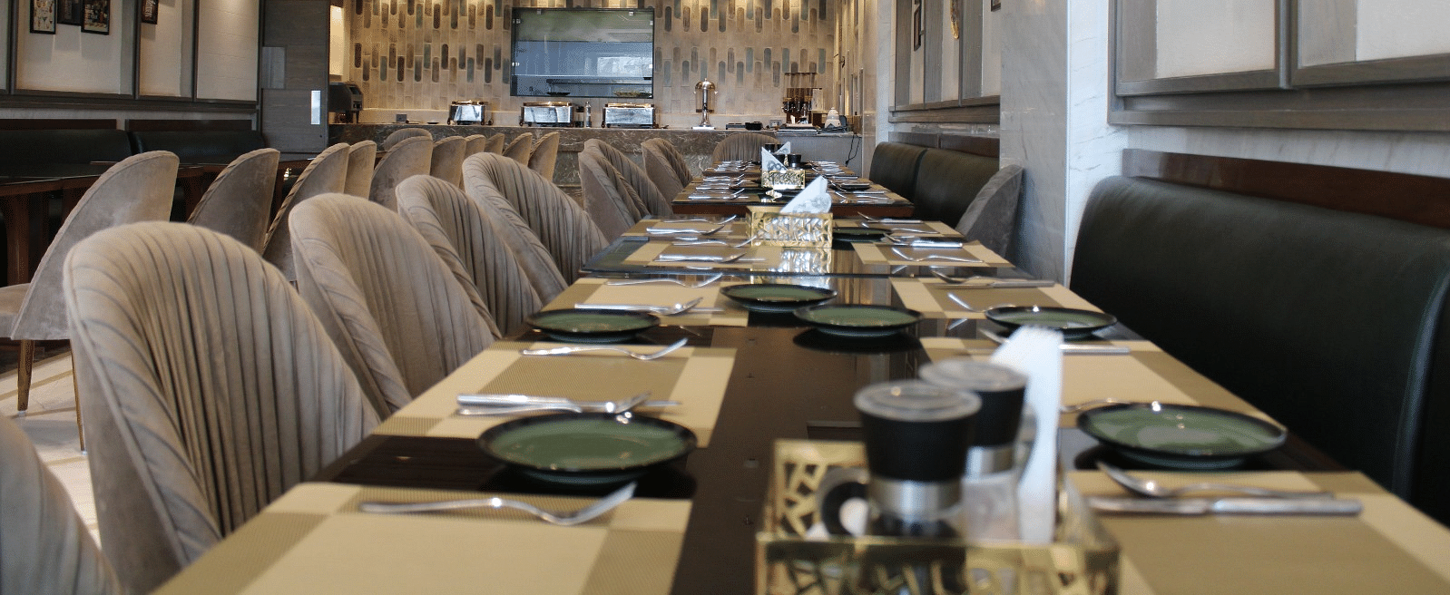 A well-arranged dining space featuring tables with chairs and neatly set cutlery at  BluSalzz Residence, Amritsar
